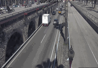 Highway sinking beneath stone arches at Barcelona port