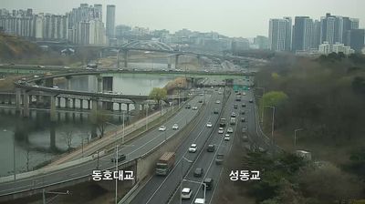 Dongho Bridge and Seongdong Bridge crossing Han River, highway in foreground, apartment towers in haze