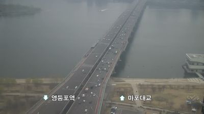 Mapo Bridge crossing the Han River from above, traffic flowing, haze obscuring far bank, Korean text overlay