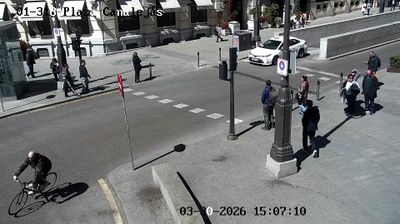 Madrid Plaza de Canalejas street corner, cyclist, pedestrians with long shadows, intimate street-level view