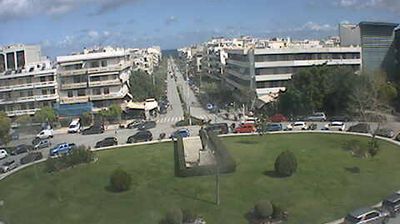 Chania courthouse square — roundabout with green park center, Mediterranean low-rise buildings, parked cars, a civic geometry