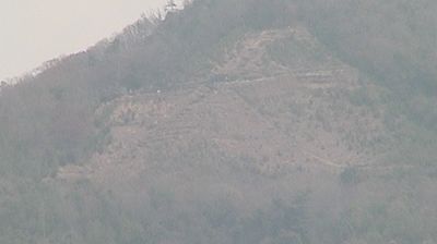 Mount Daimonji, Kyoto — bare mountain slope, leafless trees, terraced paths, hazy overcast, no people visible