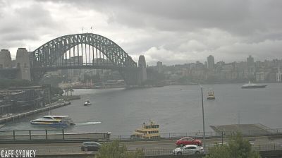Sydney Harbour Bridge arching over the water, ferries below, overcast afternoon, view from Cafe Sydney