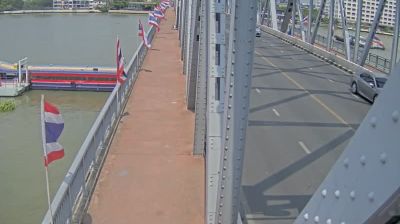 Krung Thon Bridge over the Chao Phraya — pedestrian walkway, Thai flags, steel trusses, brown river, bright tropical light